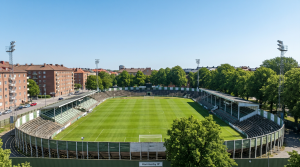 Hammarby IP idrottsplats med gr&ouml;n gr&auml;smatta och l&auml;ktare i bakgrunden